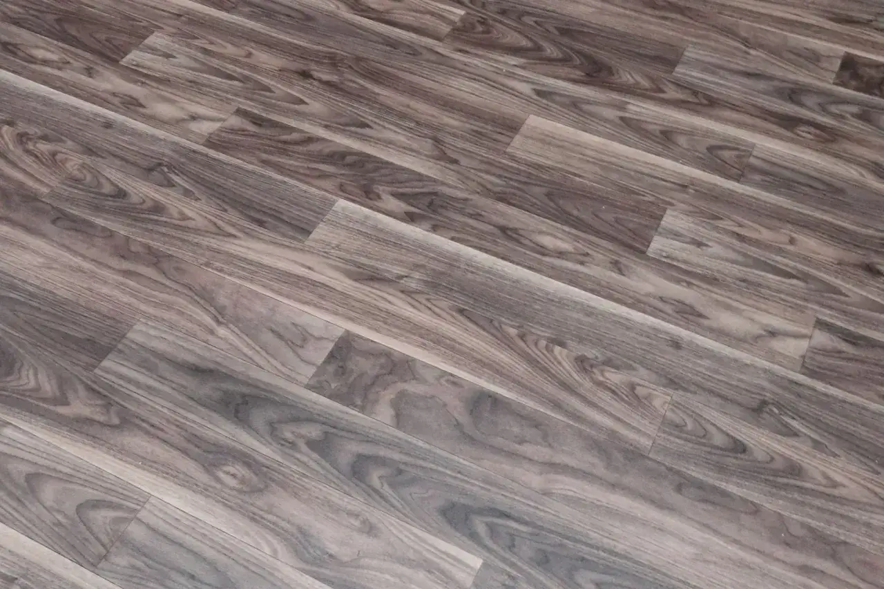 Drewnopodobne linoleum na balkon, imitujące ciemne deski z wyraźnym usłojeniem.