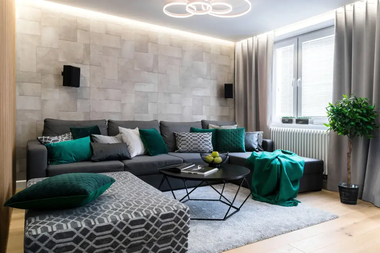 Nowoczesny salon z szaro zielonymi ścianami, wygodną kanapą i stolikiem kawowym.
