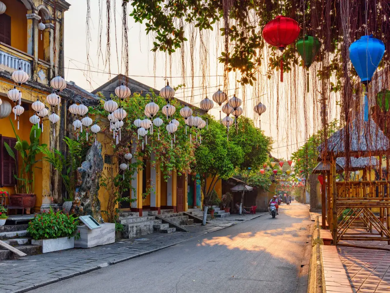 Kolorowe lampiony wiszą nad ulicą w Wietnamie. Zastanawiasz się, ile kosztuje wycieczka do Wietnamu?