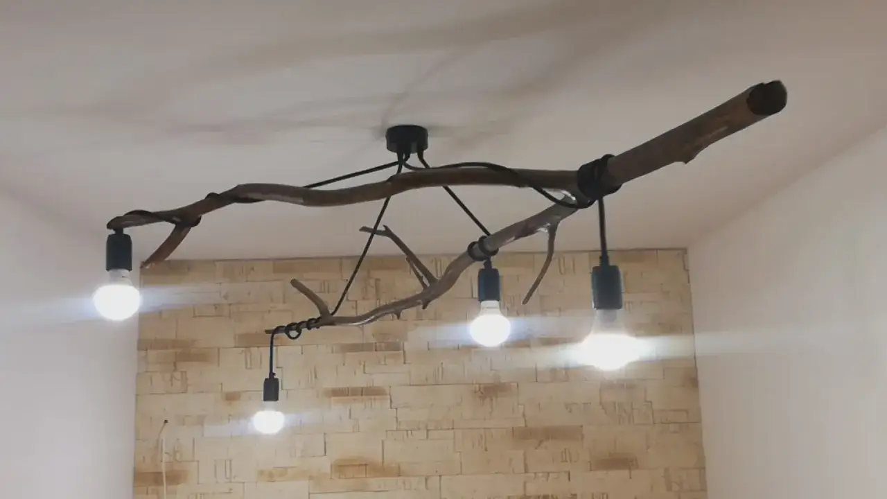 Oryginalna lampa z gałęzi z kilkoma żarówkami, tworząca niepowtarzalny, rustykalny klimat.
