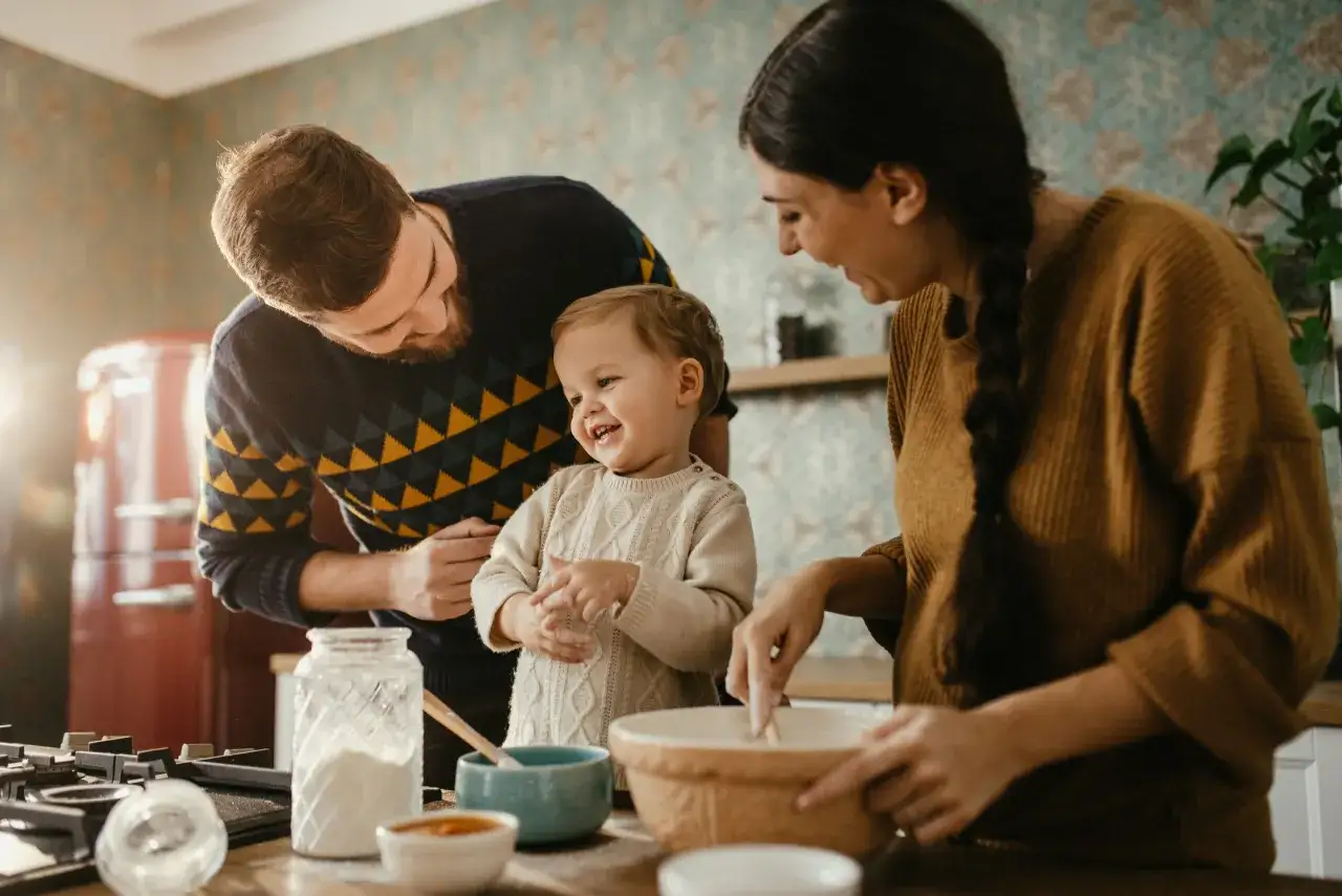 Rodzina wspólnie piecze ciasto, co oznacza self catering – samodzielne przygotowywanie posiłków. Radość dziecka i rodziców.
