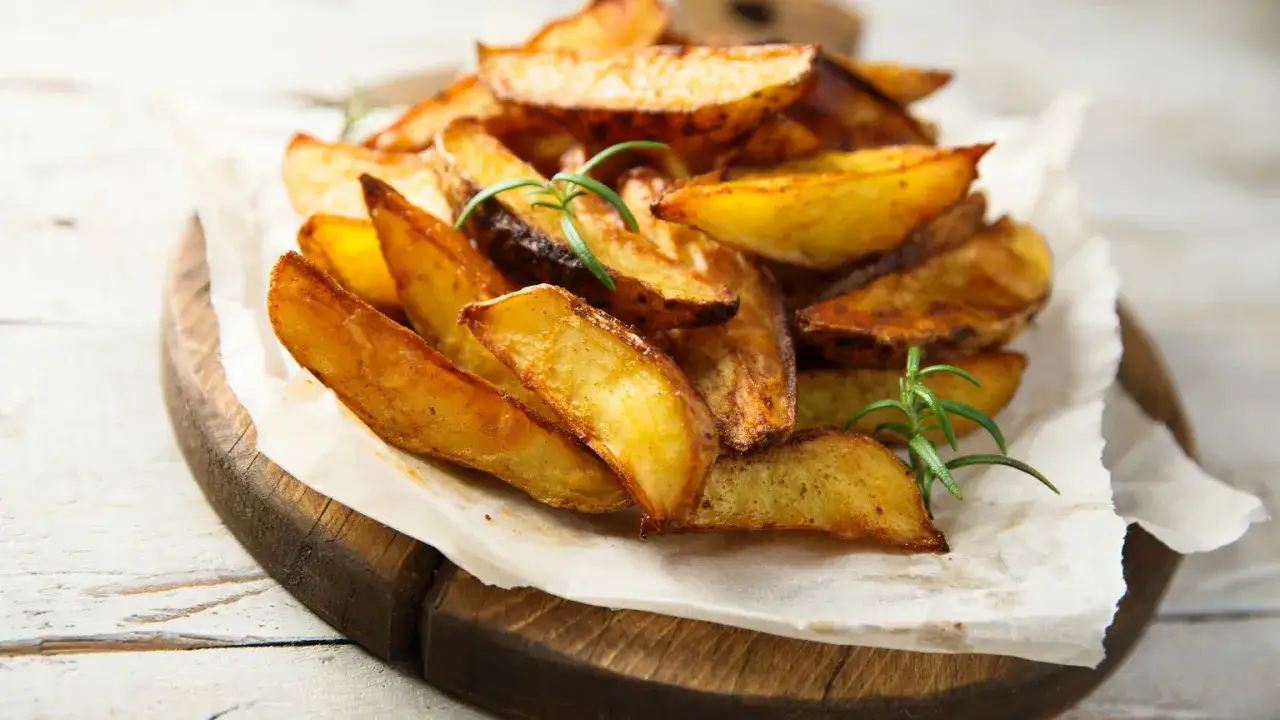 Chrupiące, złociste łódeczki ziemniaków pieczonych z rozmarynem. Odkryj najlepsze przyprawy do pieczonych ziemniaków, by uzyskać idealny smak.