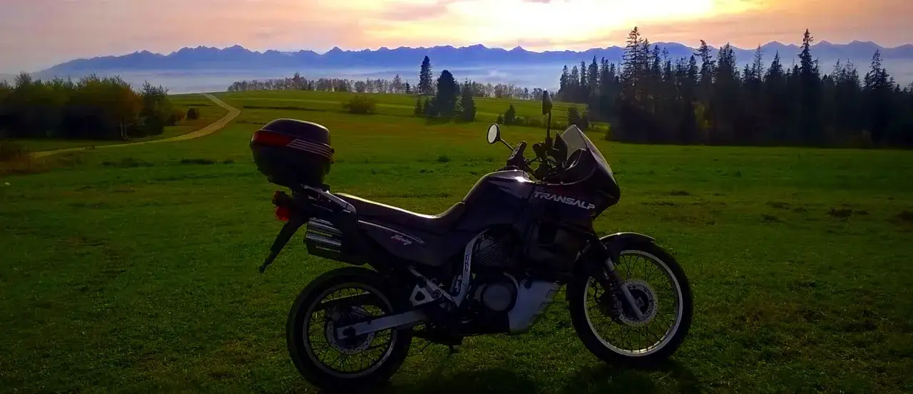 Motocykl Transalp na tle g&oacute;rskiego krajobrazu. Idealny na szlak Orlich Gniazd motocyklem.