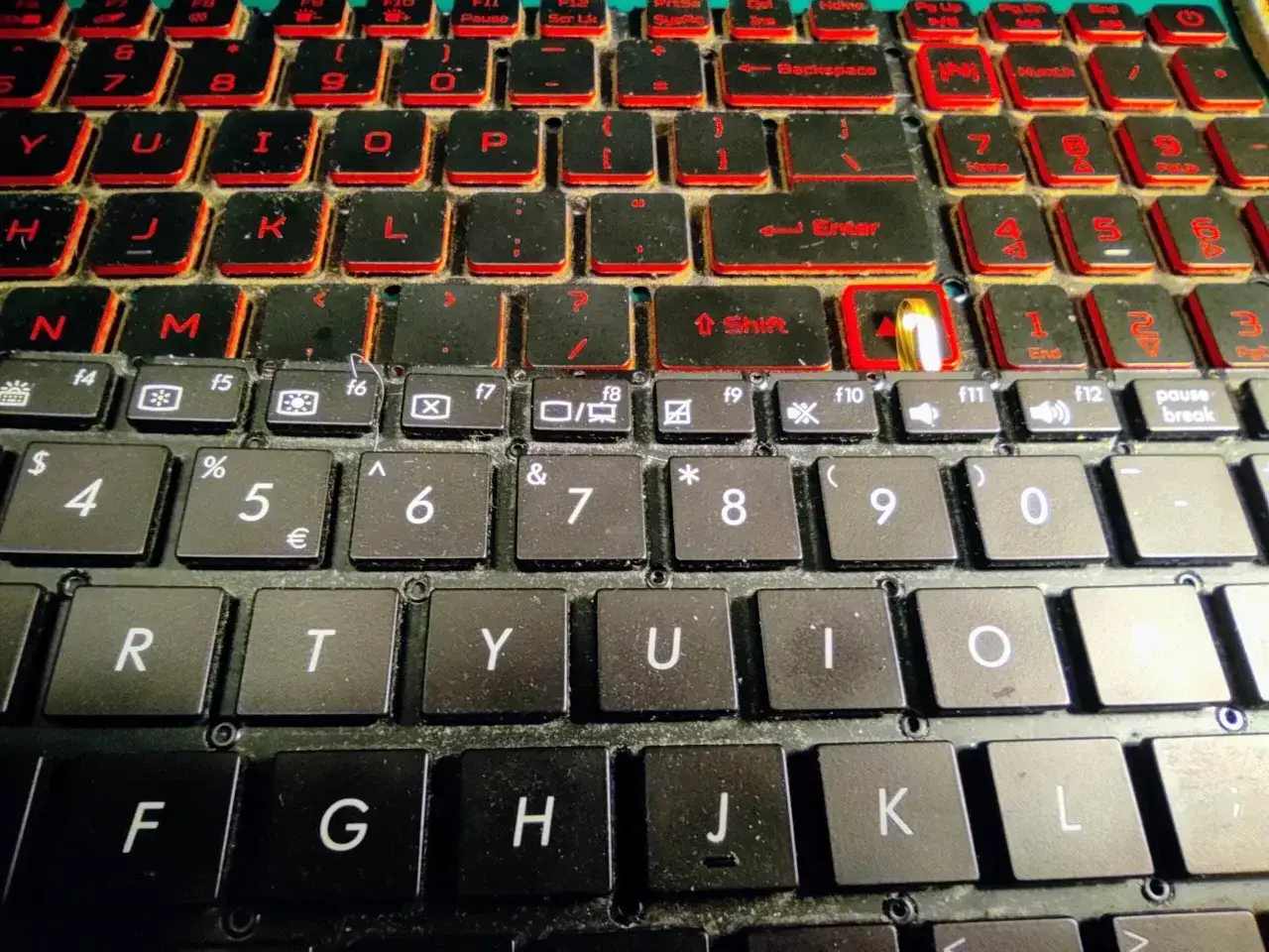 Klawiatura laptopa z czerwonym podświetleniem. Zastanawiasz się, ile kosztuje wymiana klawiatury w laptopie?