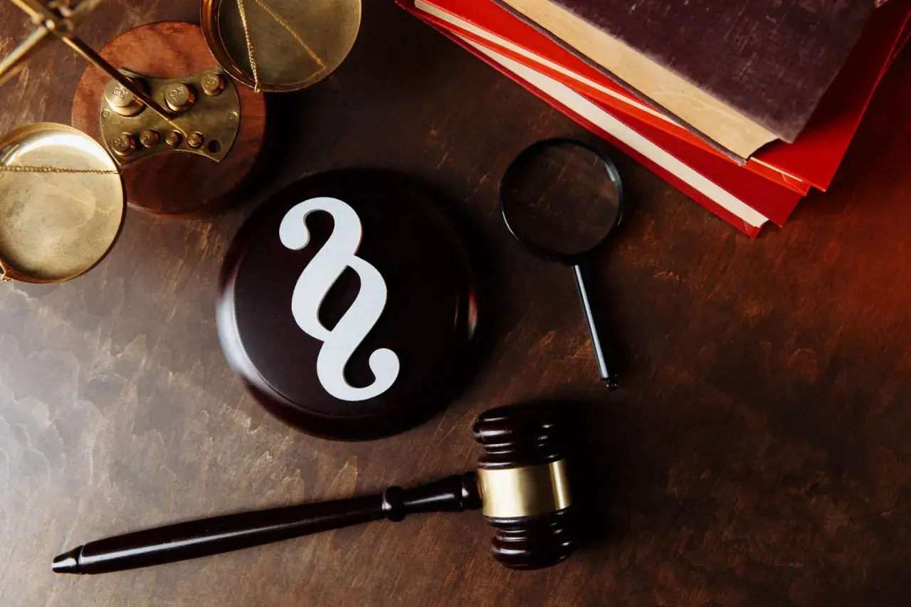 Młotek sędziowski, waga, szkło powiększające i paragraf symbolizują pracę windykatora, który dochodzi należności.