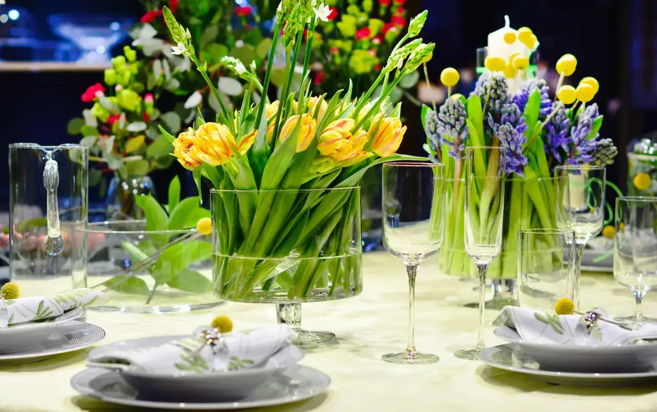 St&oacute;ł nakryty na Wielkanoc. W wazonach piękne, ż&oacute;łte tulipany i fioletowe hiacynty. Wielkanocne kwiaty tworzą radosną atmosferę.