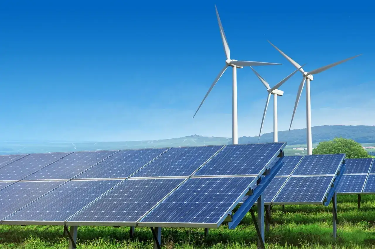 Panele słoneczne i wiatraki na tle błękitnego nieba. To przyszłość, kt&oacute;rą można zobaczyć na targach energii odnawialnej.