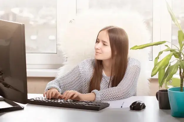 młoda osoba pracuje w małym biurze z laptopem