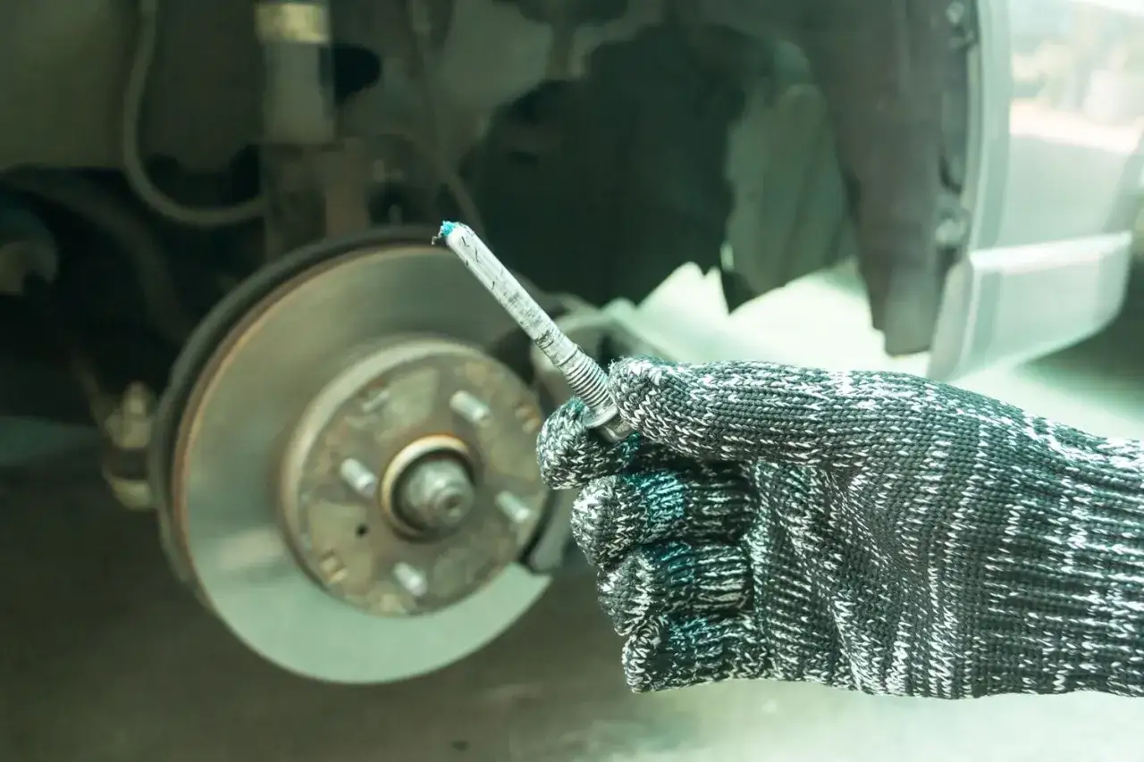 Rękawica z niebieskim smarem na śrubie, gotowa do użycia. Jaki smar do prowadnic hamulcowych? Ten wygląda obiecująco.