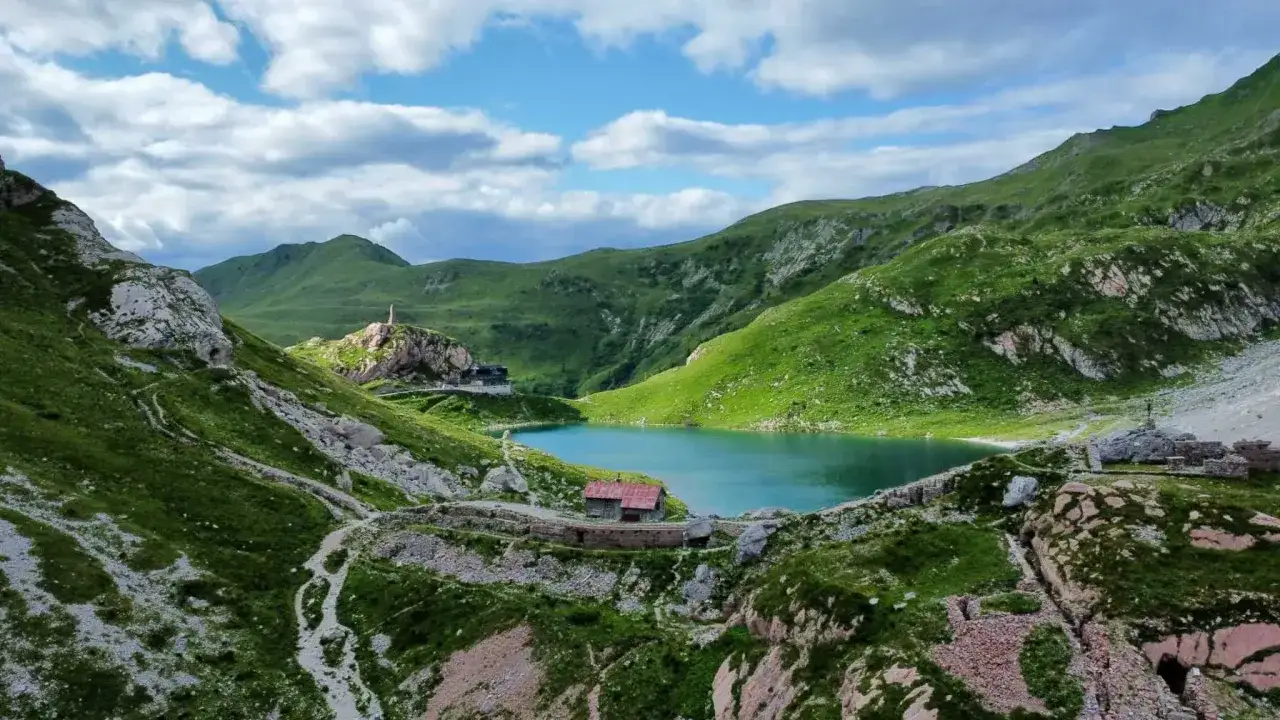 G&oacute;ry Albanii, gdzie najpiękniej: turkusowe jezioro otoczone zielonymi wzg&oacute;rzami, kamienne budowle i szlak wiodący ku przygodzie.
