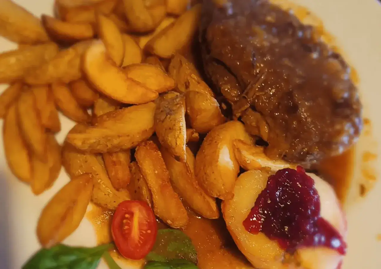 Pyszny obiad w Piotrkowie: pieczone ziemniaki, sos mięsny, jabłko z żurawiną i pomidorek. Idealne miejsce, gdzie na lunch w Piotrkowie.