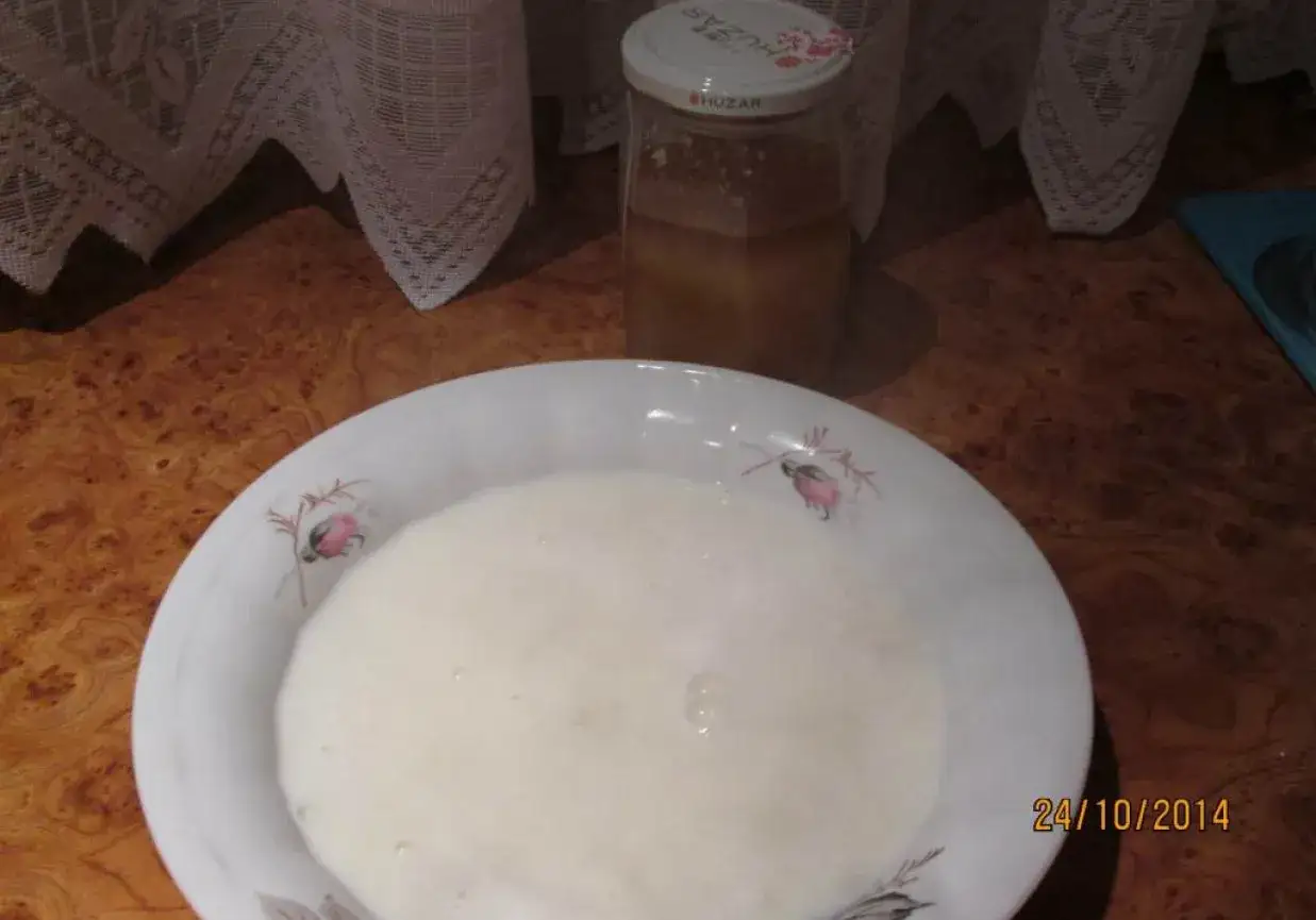 Biała zupa mleczna w misce, obok słoik miodu. Zastanawiam się, ile kaszy manny na litr zupy będzie idealne.