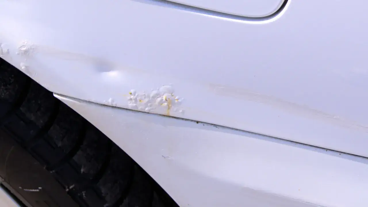 Rdza i wgniecenie na białym progu samochodu. Jak załatać dziurę w samochodzie? Czas na naprawę!