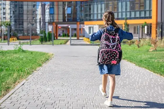 dziecko z plecakiem idące do szkoły z uśmiechem, odporność psychiczna