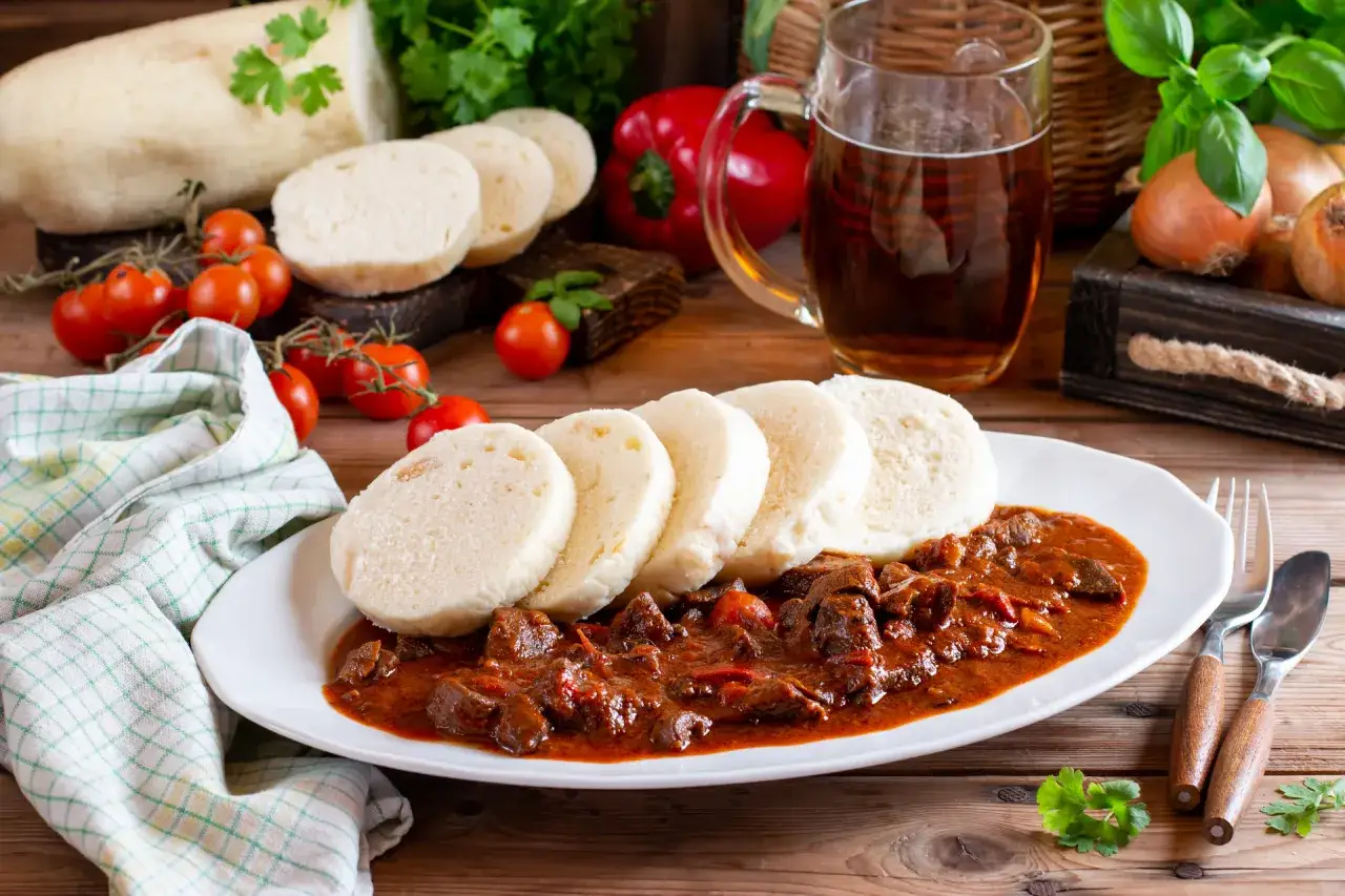 Gulasz z knedlami i kufel piwa – idealne danie, co warto zjeść w Czechach.