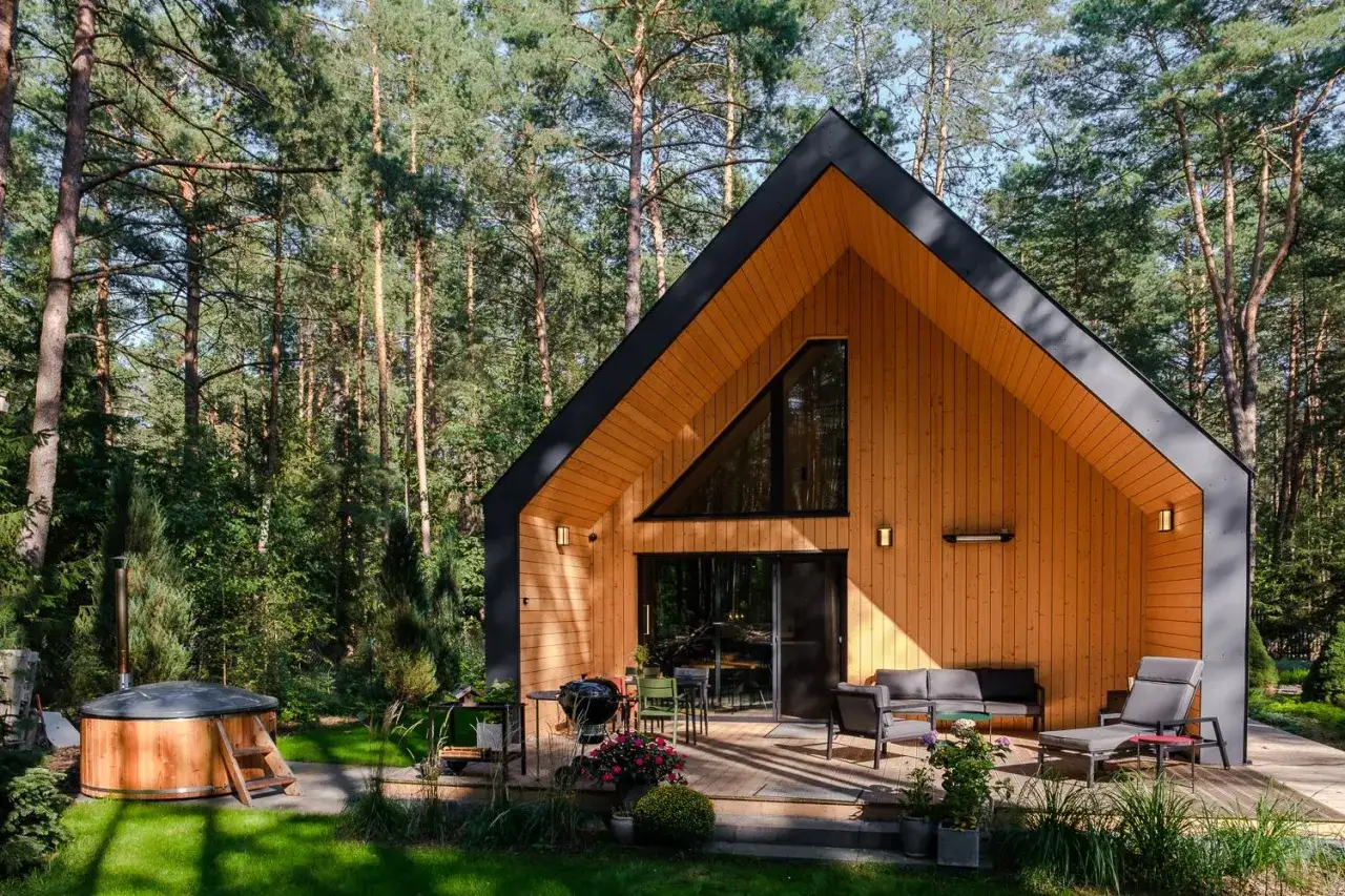 Nowoczesny dom kanadyjski w lesie, z tarasem, jacuzzi i grillem. Zastanawiasz się, ile kosztuje budowa domu kanadyjskiego?