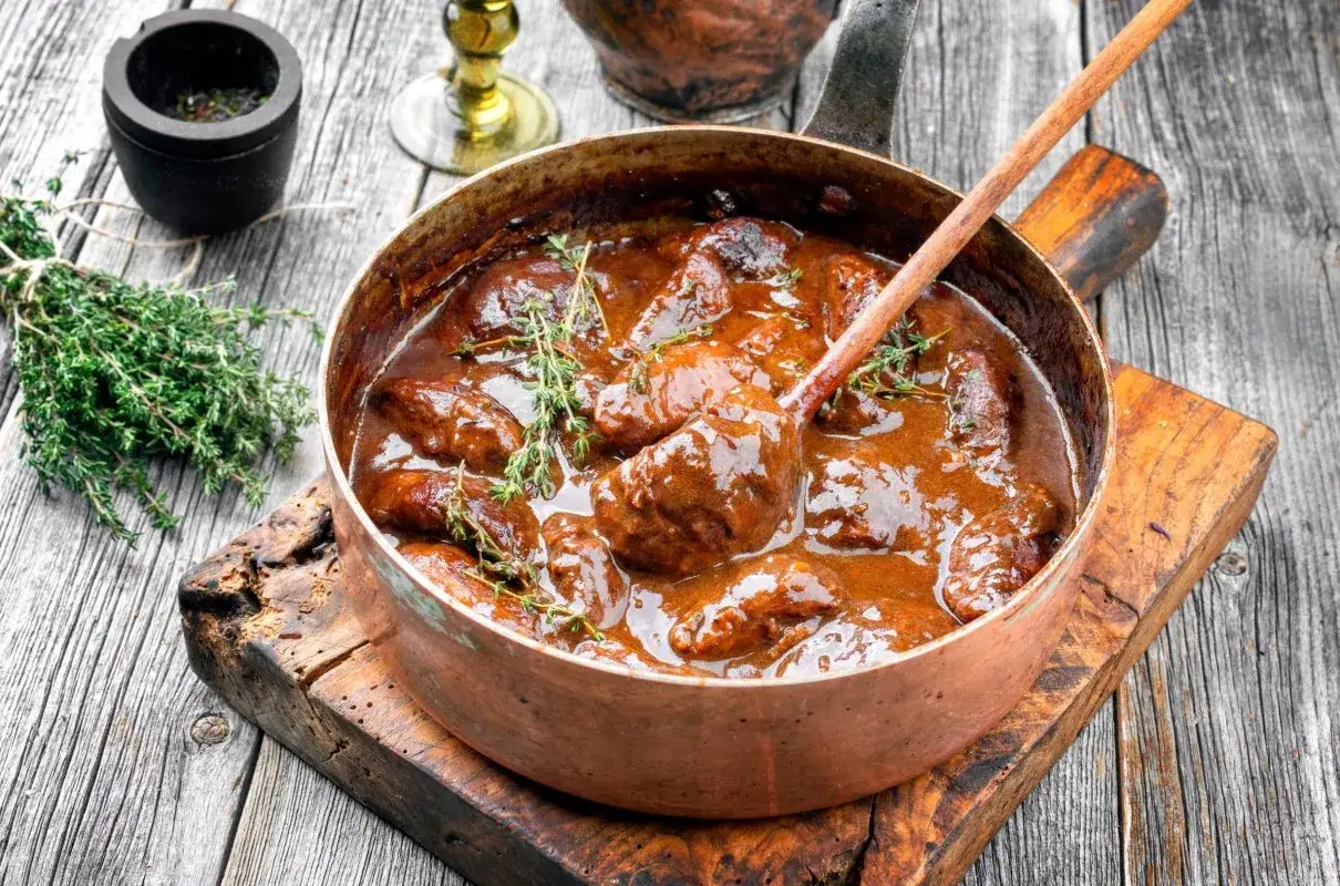 Gulasz wieprzowy w miedzianym rondlu, z gałązkami tymianku. Idealny przykład, ile dusic wieprzowine, by uzyskać ten smak.