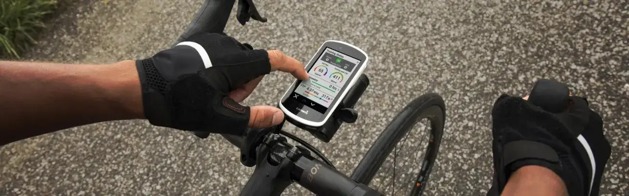 Rowerzysta sprawdza na ekranie swojego Garmin Hammerhead Karoo 3 dane treningowe, takie jak VO2 Max i FTP.