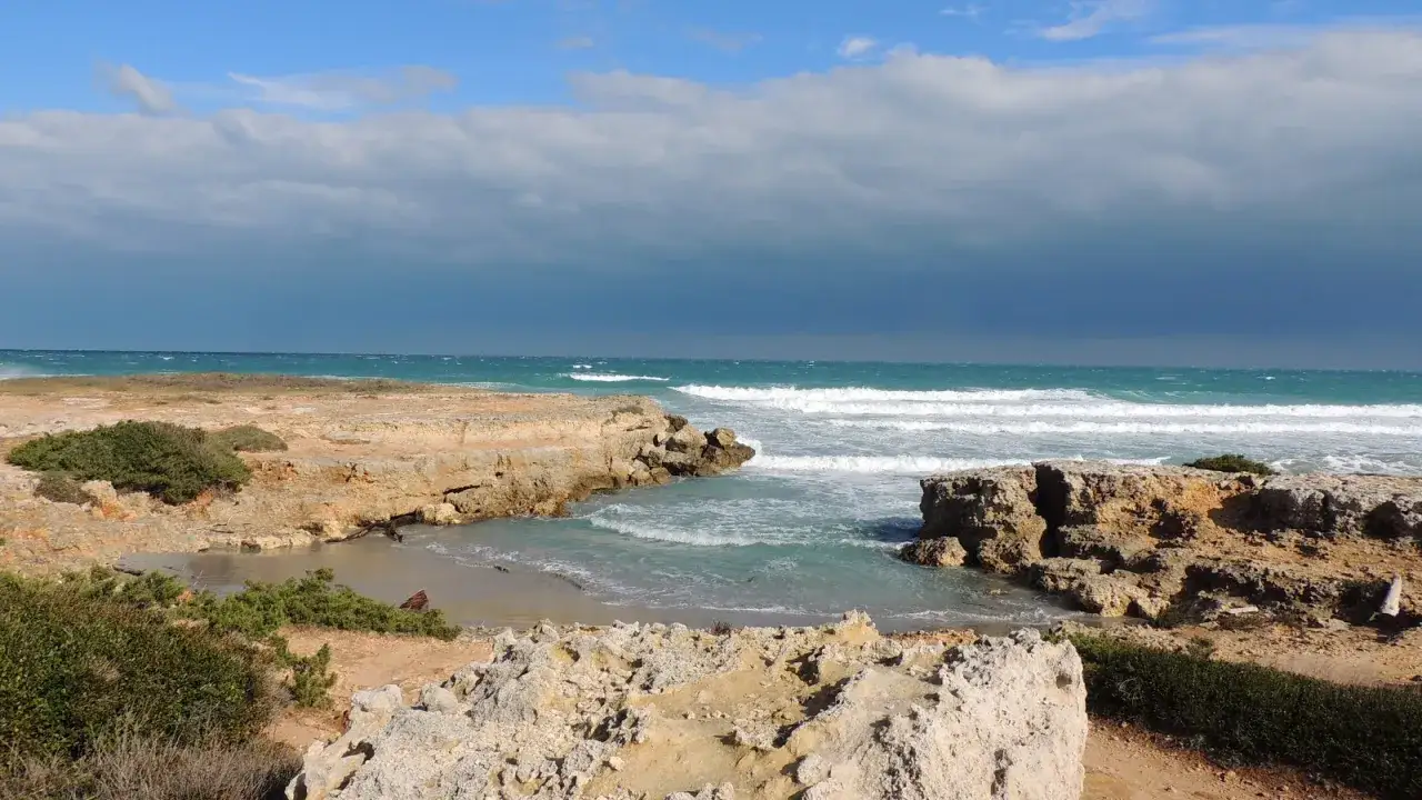 Spiaggia segreta Italia caletta rocciosa acqua cristallina