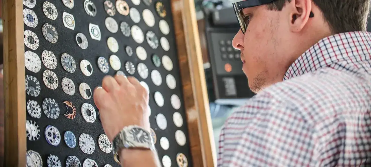 Mężczyzna wybiera tarczę zegarka. Czas oczekiwania na okulary może być długi, ale warto!