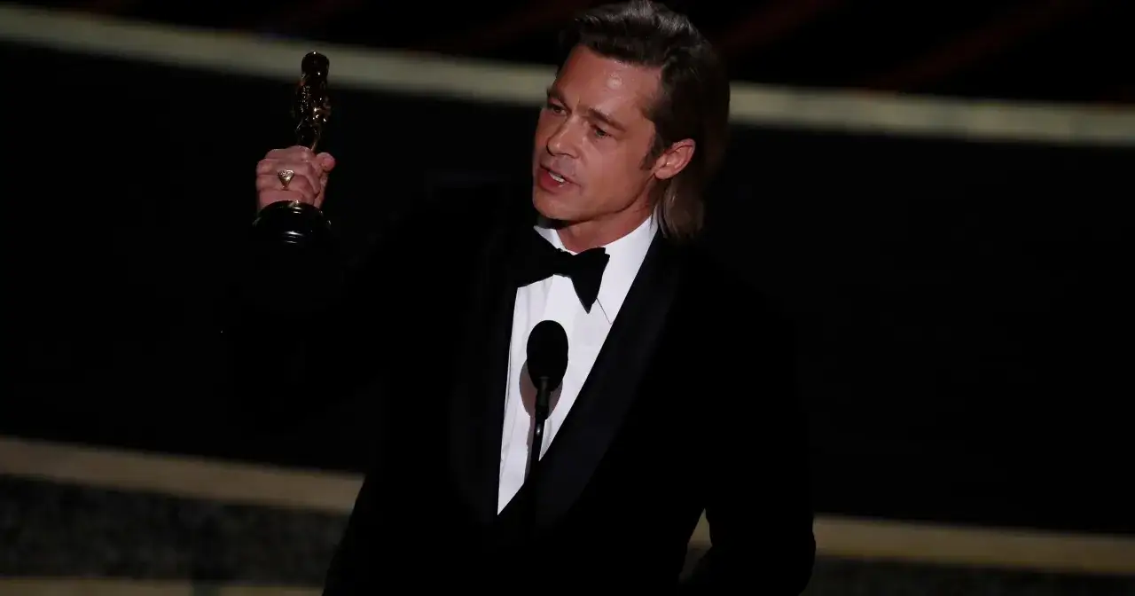 Brad Pitt z Oscarem w ręku, potwierdzając, czy Brad Pitt dostał Oscara.