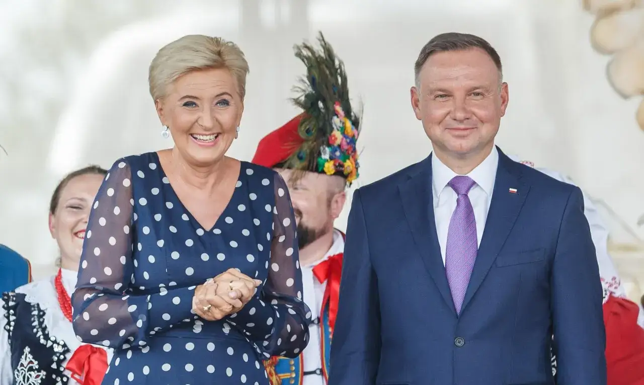 Agata Kornhauser-Duda w granatowej sukience w grochy uśmiecha się obok prezydenta. Czy żona prezydenta może pracować? Ona na pewno pracuje!