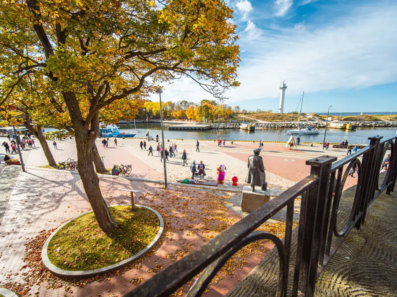 Jesień w Kołobrzegu. Spacerowicze, łodzie i latarnia morska. Zastanawiasz się, ile kosztuje klimatyczne w Kołobrzegu?