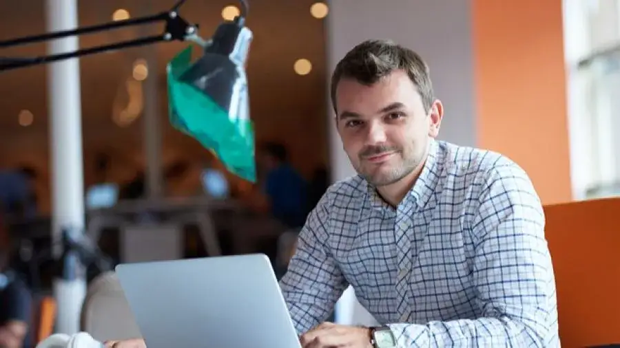 Młodzi ludzie szukający ofert pracy na laptopie lub na targach pracy