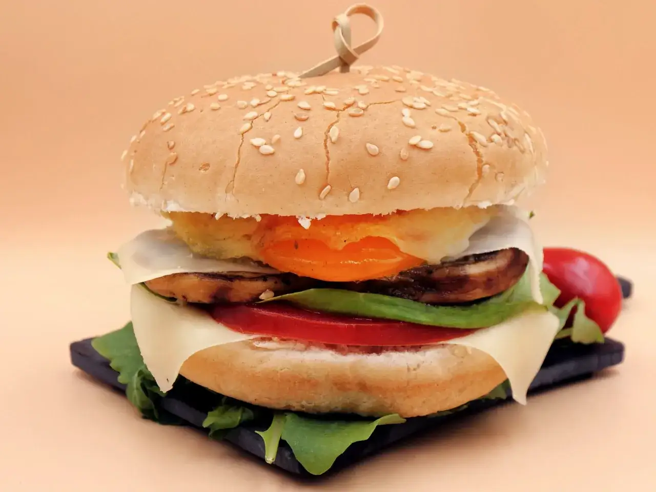 Pyszny wege burger z serem, pomidorem, pieczarkami i jajkiem sadzonym. Zastanawiasz się, ile kalorii ma wege burger?