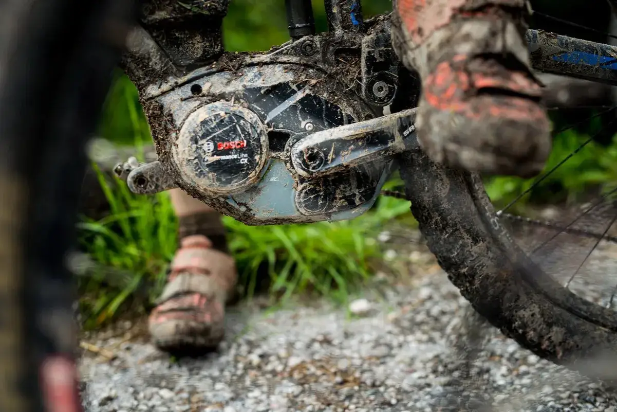 Błotnisty rower elektryczny Bosch po przejażdżce w deszczu. Błoto pokrywa silnik i opony, ale jazda była tego warta.