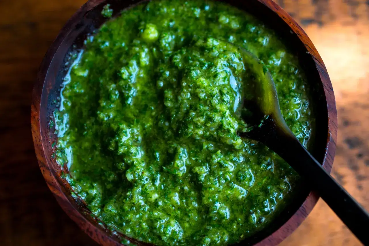 Aksamitne pesto w drewnianej misce, z łyżką. Czy pesto jest zdrowe? Tak, jeśli przygotowane ze świeżych składnik&oacute;w!