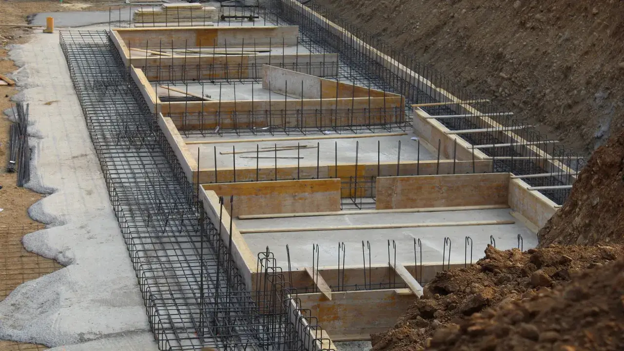 Szkielet zbrojeniowy i szalunki drewniane czekają na beton. Tak wygląda początek, jak wybudować fundamenty.