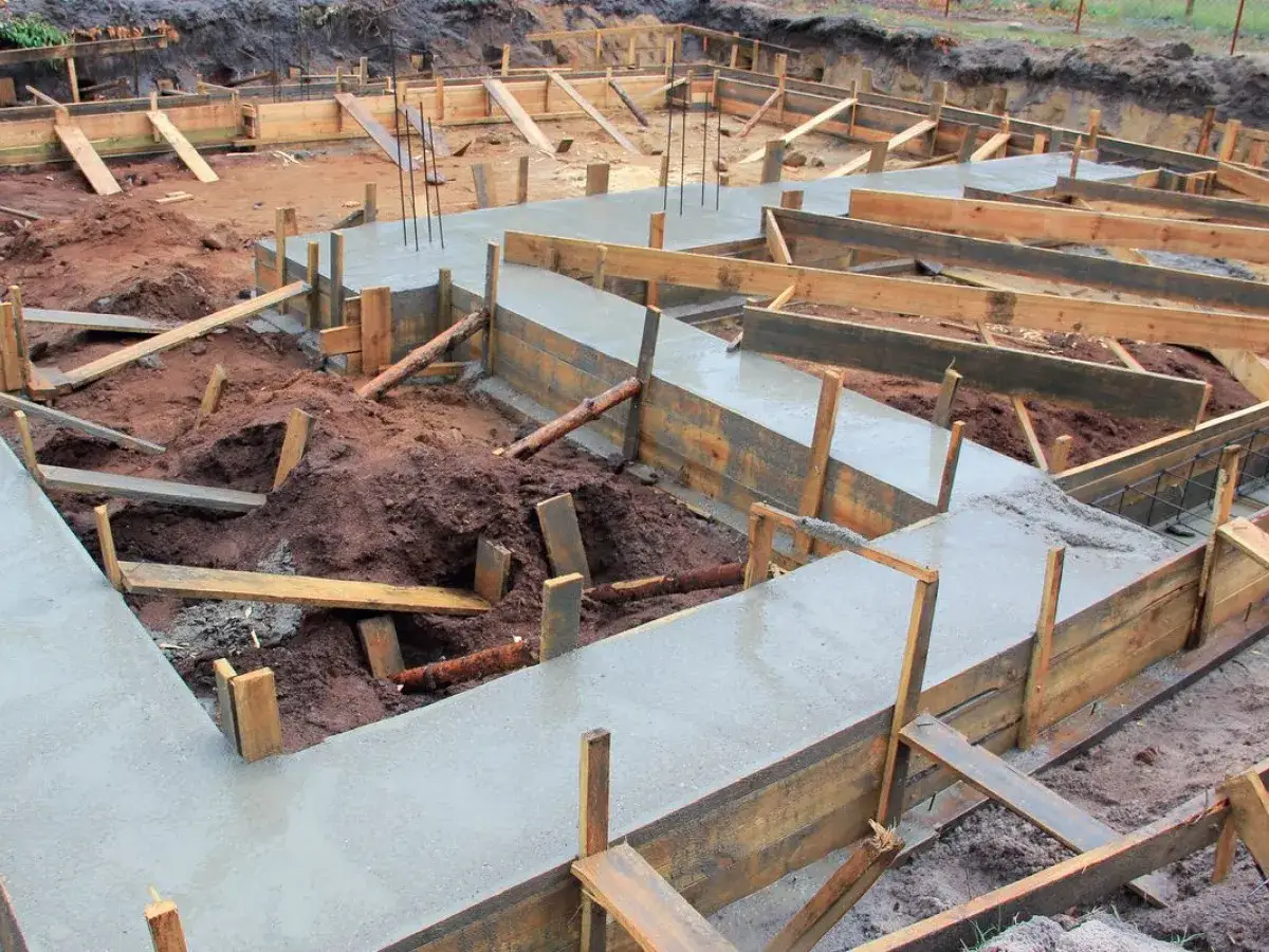 Budowa fundamentów: świeży beton w drewnianym szalunku. Dobry cement na fundamenty to klucz do trwałości.