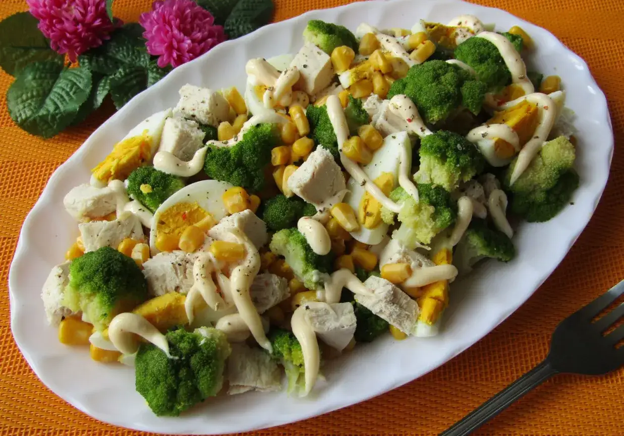 Pyszna sałatka z brokułem i kurczakiem, jajkiem i kukurydzą, polana majonezem.