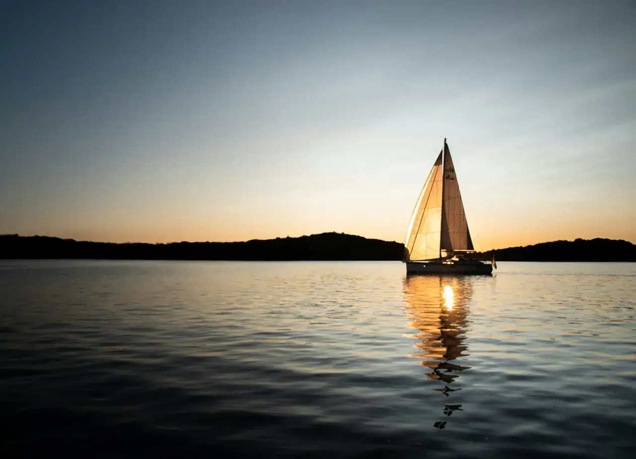wei&szlig;es Segelboot Sonnenuntergang Meer