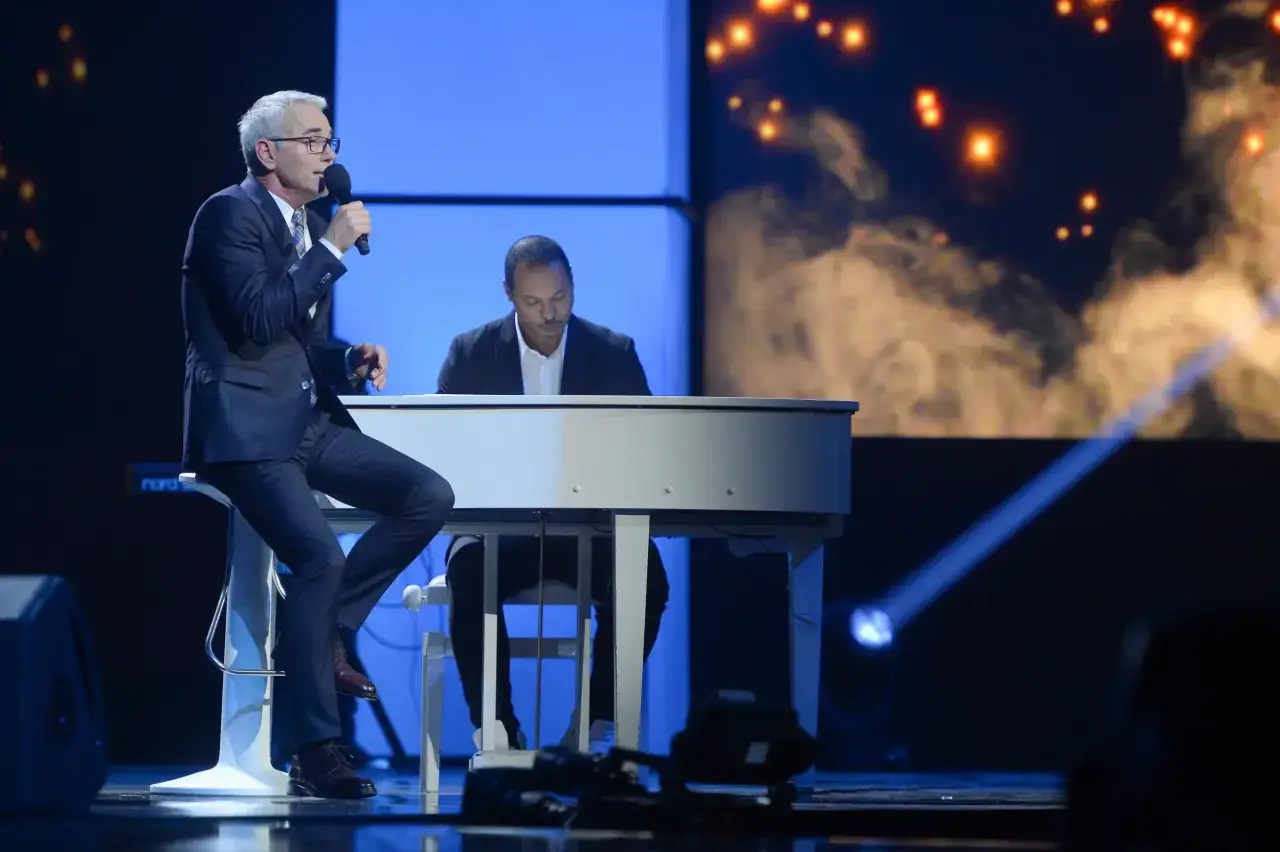 Robert Janowski śpiewa do mikrofonu, siedząc na stołku. Obok gra pianista. Czy to scena, która wyjaśnia, dlaczego Robert Janowski naprawdę odszedł z Jaka to melodia po latach?