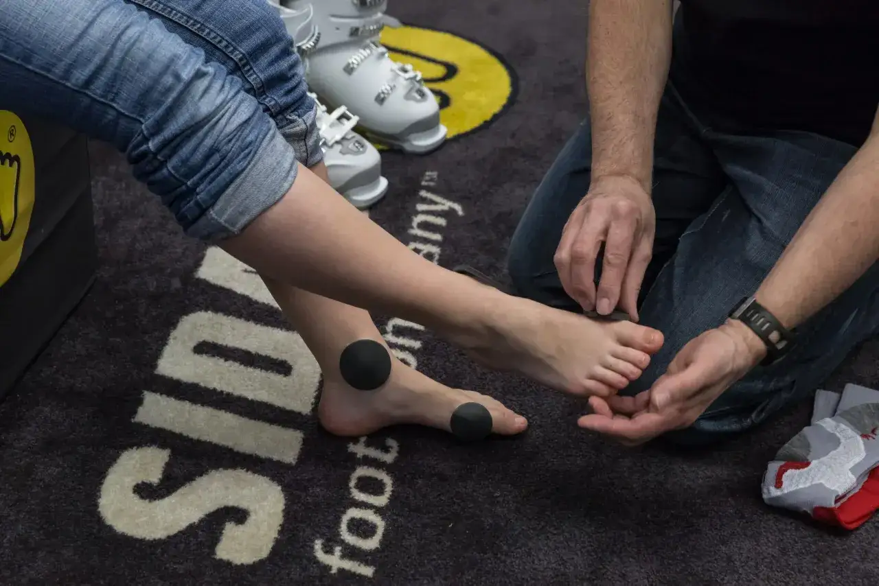 Osoba mierząca stopę do butów narciarskich