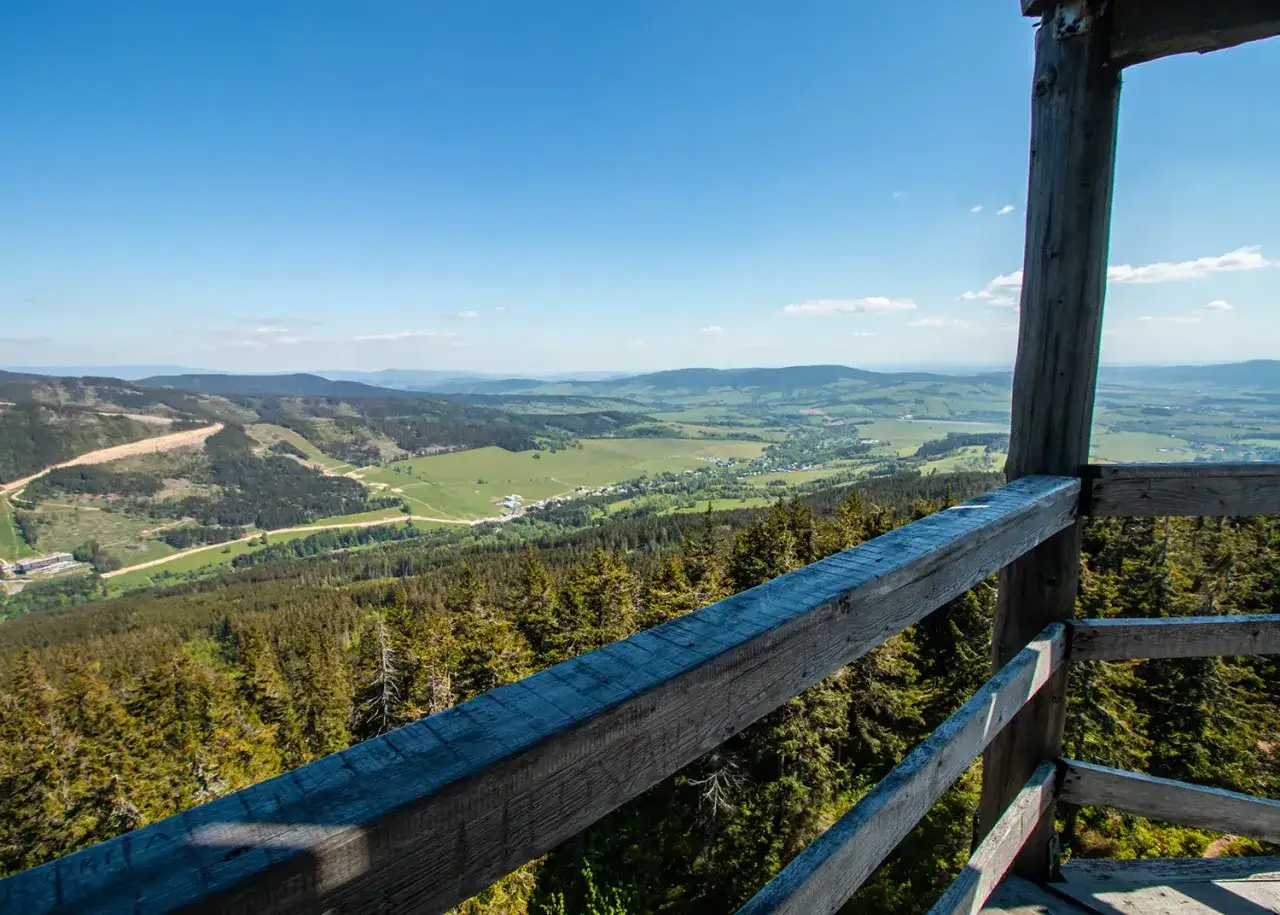 Widok z wieży widokowej Tr&oacute;jmorski Wierch na zielone doliny i lasy.