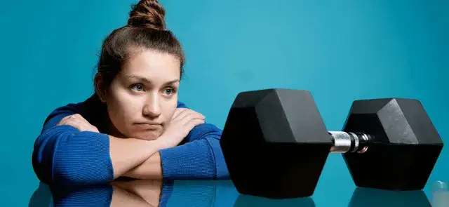 osoba zmagająca się z brakiem chęci do treningu, ale wstająca i idąca ćwiczyć