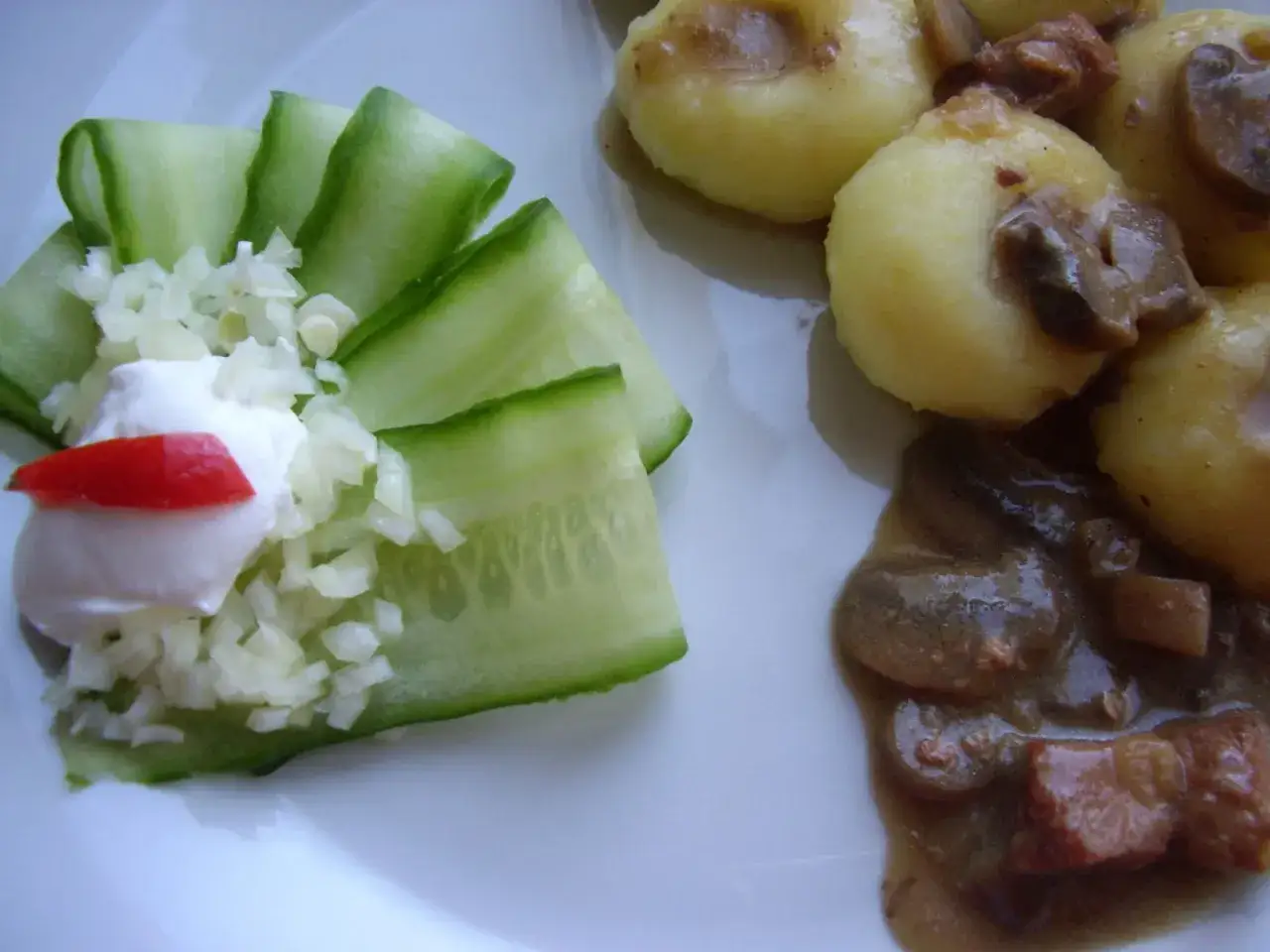 Pyszny gulasz na obiad z kluskami ziemniaczanymi i ogórkiem z czosnkiem.