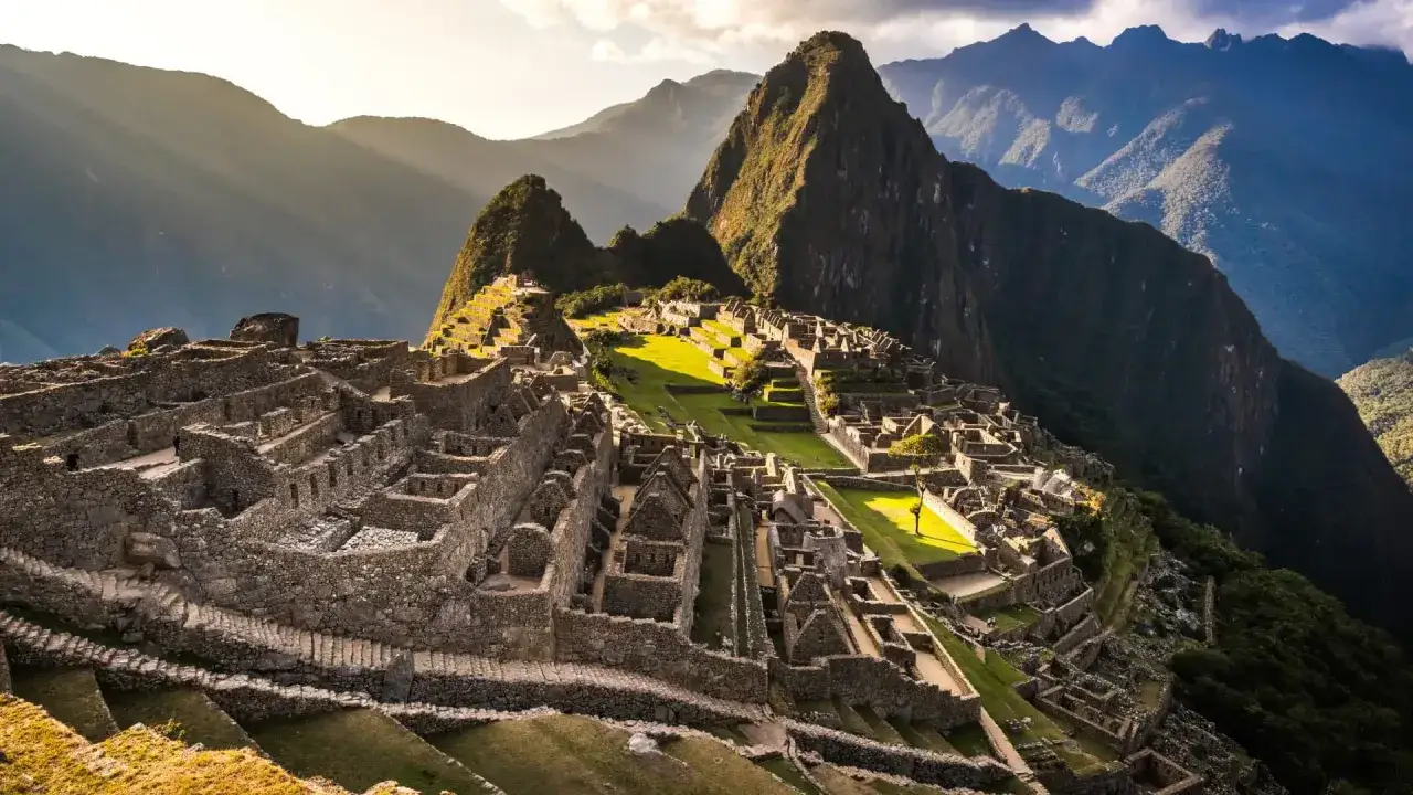 Machu Picchu, z jego tarasami i kamiennymi budowlami, w promieniach słońca. Ciekawe, jak starożytni budowali w tak trudnym terenie!