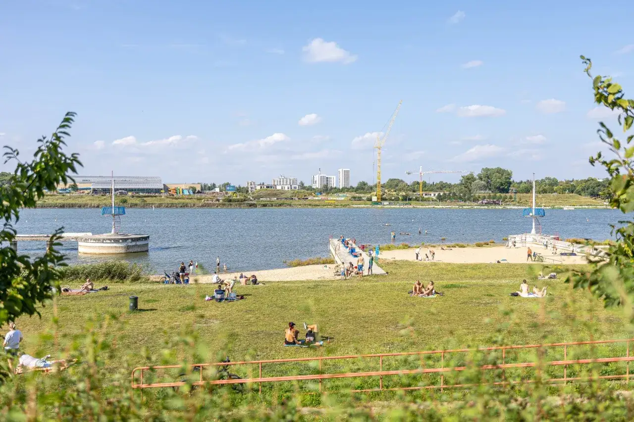 Słoneczny dzień nad jeziorem w Poznaniu, idealne miejsce na relaks i plażowanie. To świetne poznańskie atrakcje dla par szukających odpoczynku.