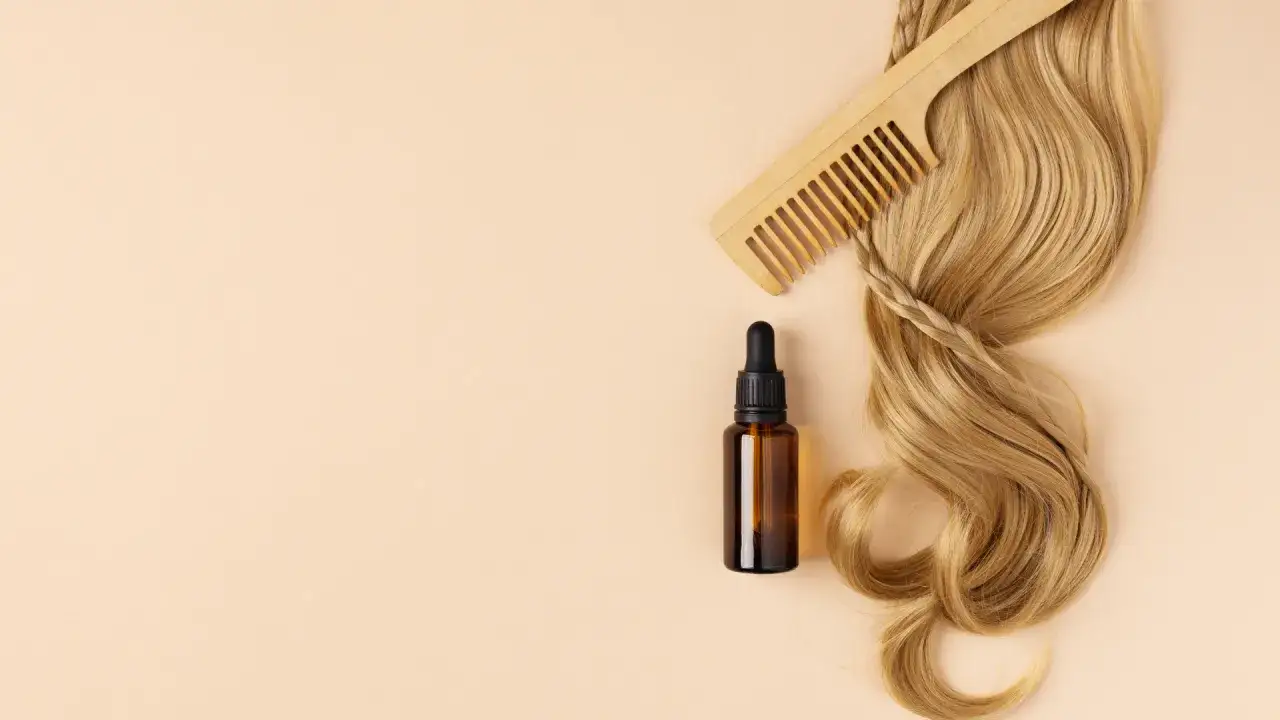 Olej do włosów wysokoporowatych, drewniany grzebień i pasmo blond włosów. Idealny zestaw do pielęgnacji.