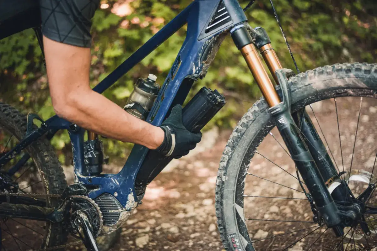 Rowerzysta wyjmuje baterię z napędu **Shimano EP8** w rowerze g&oacute;rskim.
