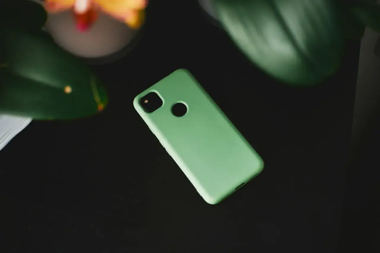 Mięta etui na telefon leży na czarnym tle. Zastanawiasz się, czym umyć etui od telefonu? Delikatne czyszczenie wodą z mydłem powinno wystarczyć.