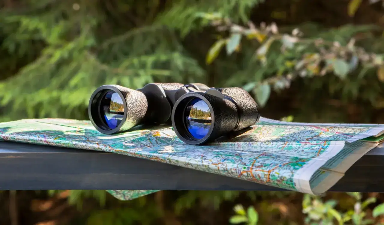 Lornetka na mapie, gotowa na wyprawę. Idealna, by sprawdzić, jaka lornetka w g&oacute;ry będzie najlepsza do podziwiania widok&oacute;w.