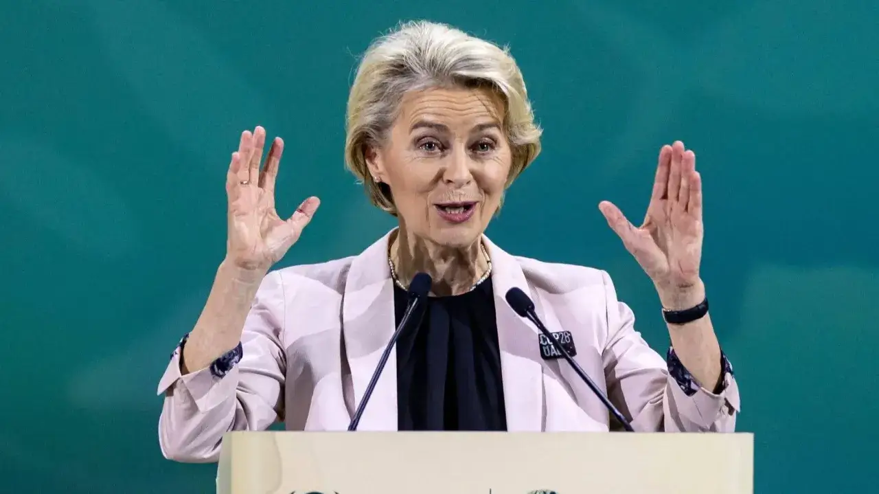 Ursula von der Leyen, która wymyśliła Zielony Ład w Europie, przemawia z podniesionymi rękami.