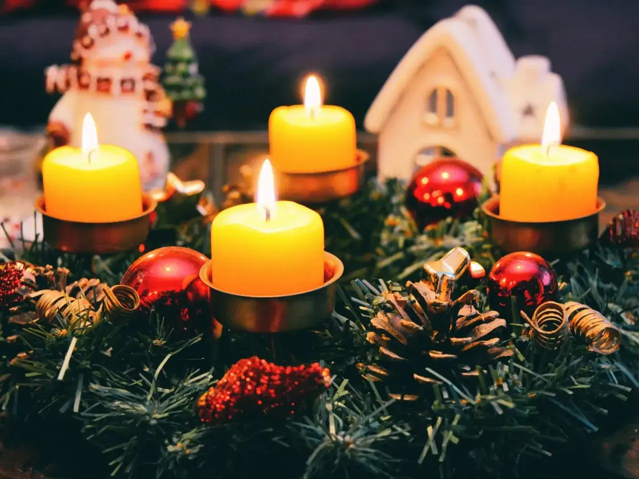 Wieniec adwentowy z płonącymi świecami, bombkami i szyszkami. Czy picie alkoholu w adwencie to grzech?