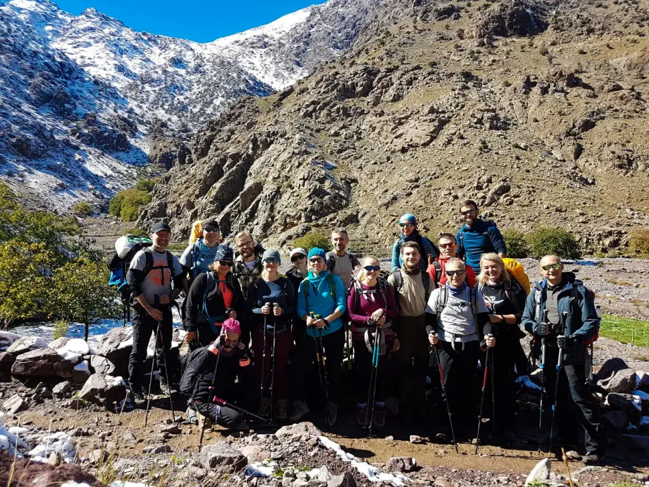 Grupa turyst&oacute;w na tle ośnieżonych g&oacute;r podczas wyprawy na Toubkal.