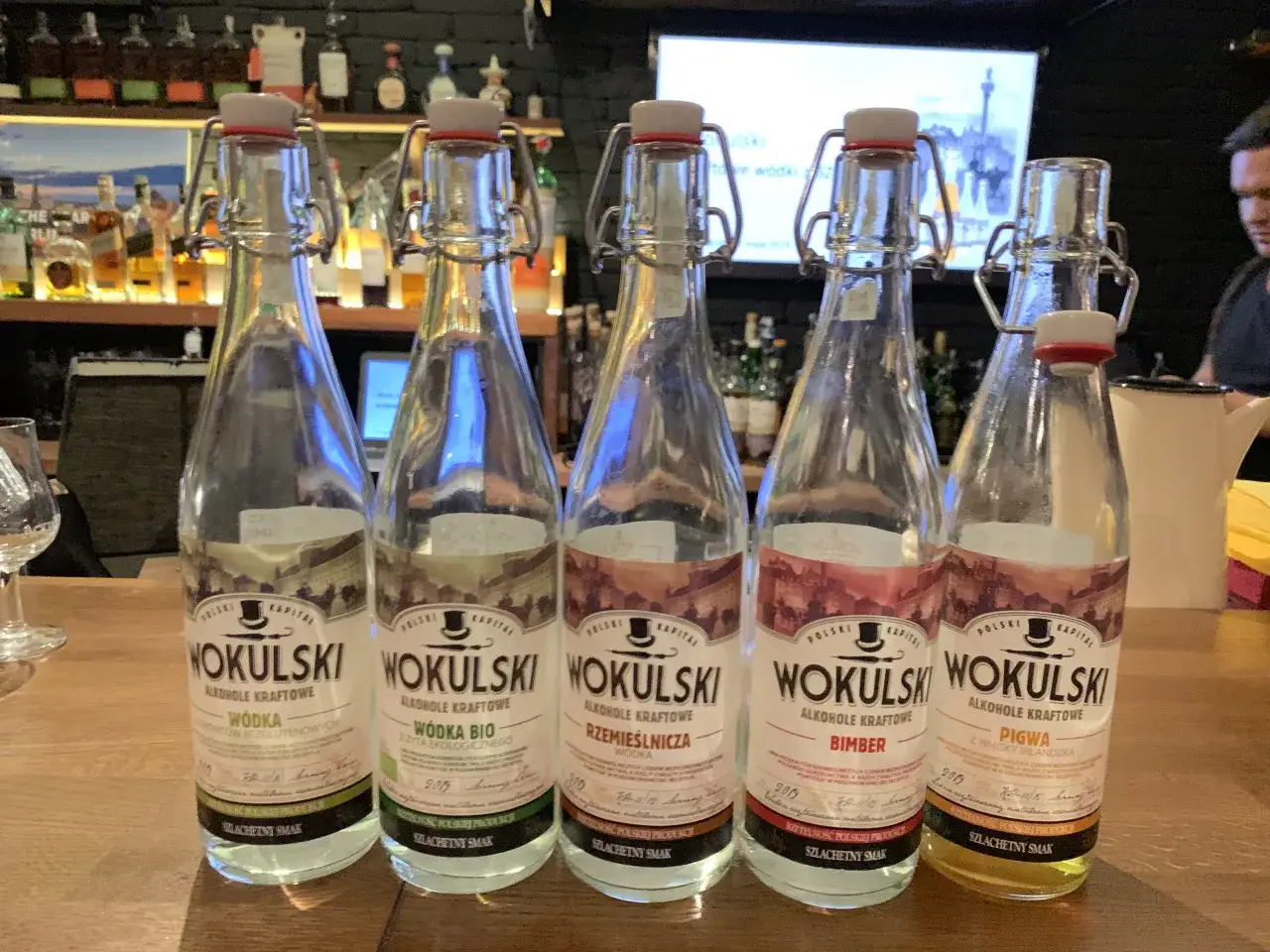 Pięć butelek wódki kraftowej Wokulski: czysta, bio, rzemieślnicza, bimber i pigwa. To pokazuje, co to znaczy wódka kraftowa – unikalne smaki i polskie produkty.